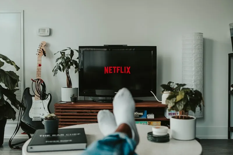 Hand holding a streaming remote pointed at a television
